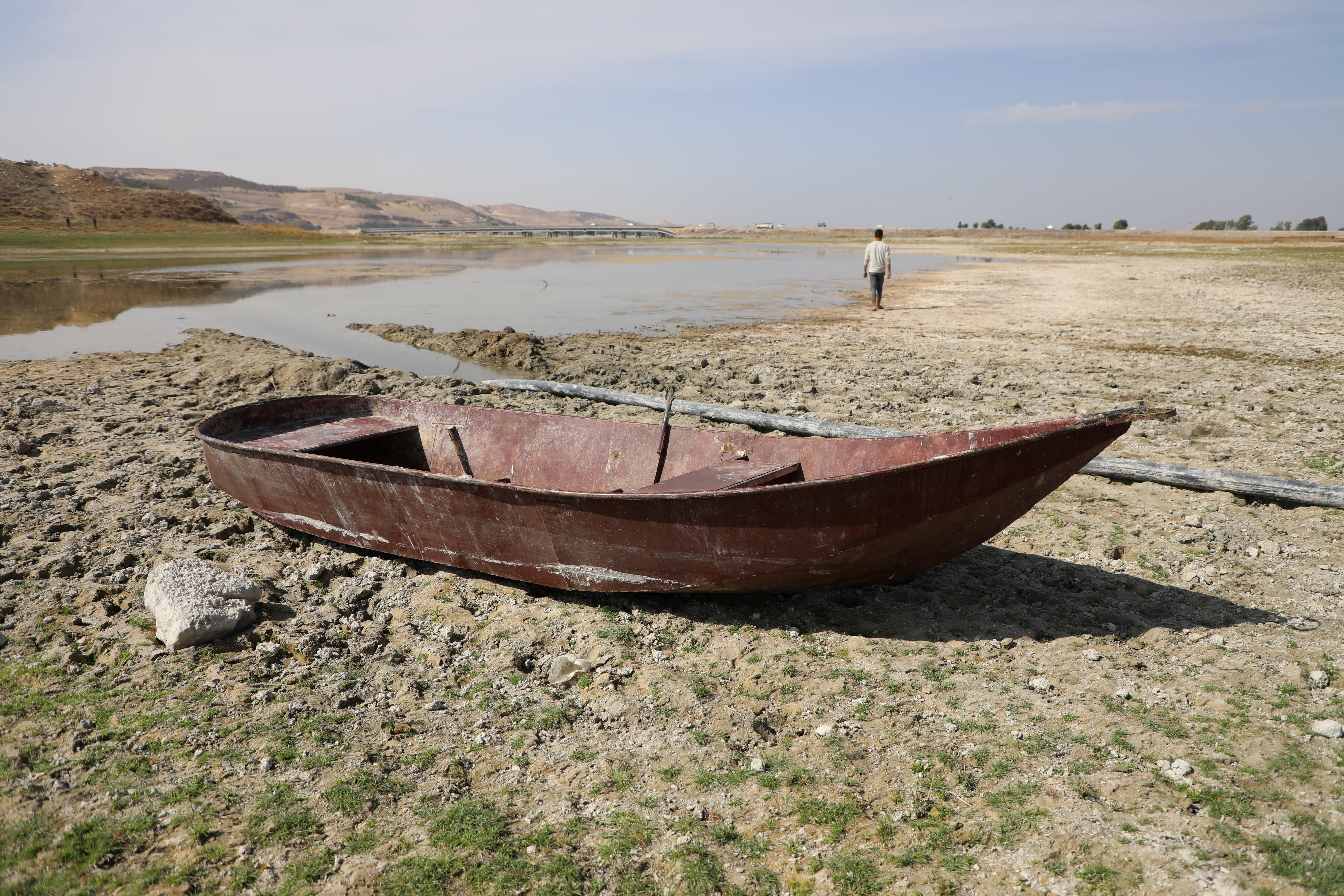 A boat lies on the dried out shore of the Euphrates river in Syria.