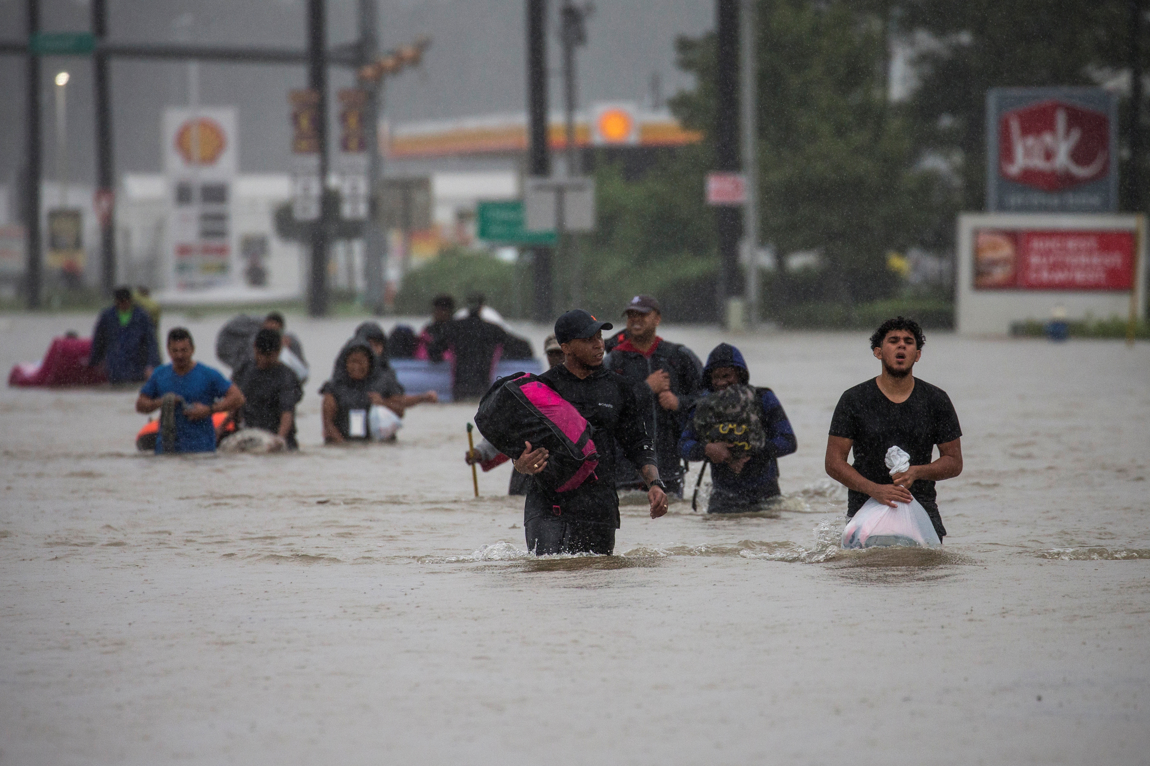 Residents wade through flood waters from Tropical Storm Harvey.